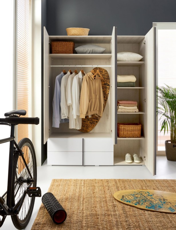 Wnętrze otwartej szafy Remo z drążkiem na wieszaki, półkami i szufladami na dole